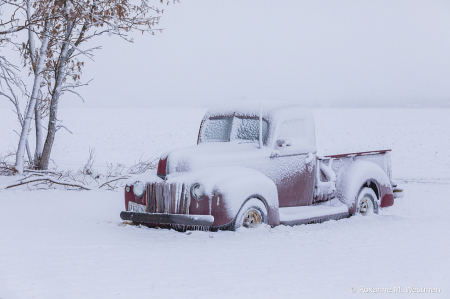 Vintage Red Ford truck in snow