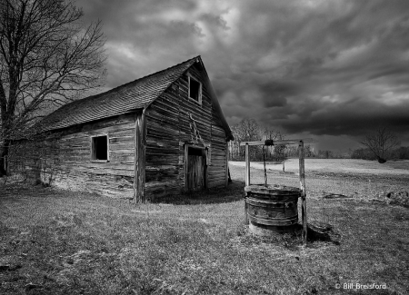 old barn and well in b&w