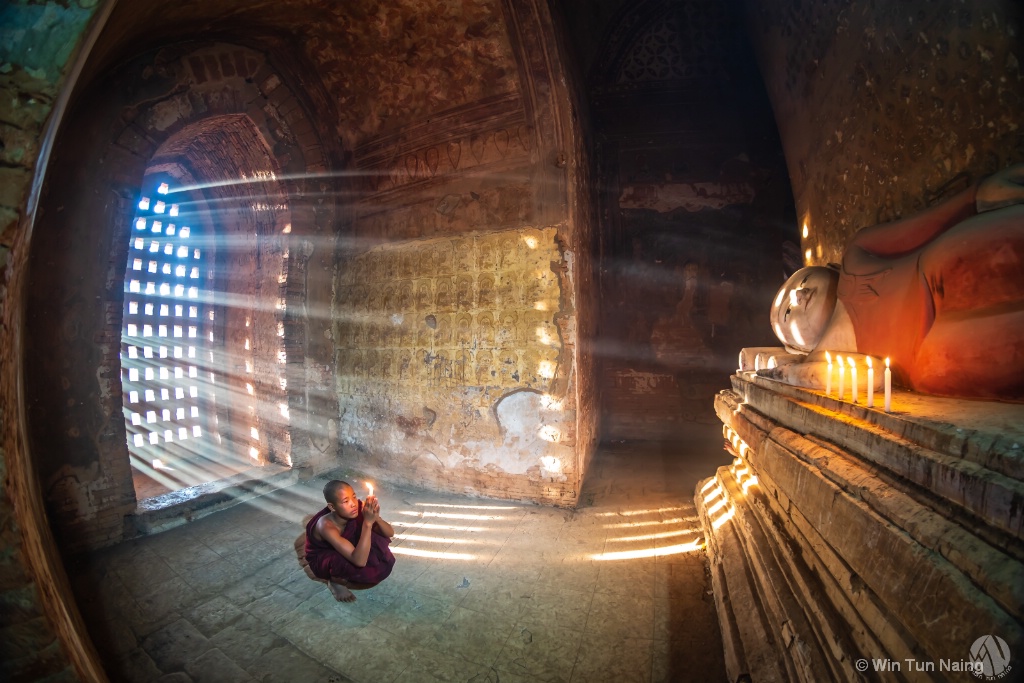 A novice praying in front of Buddha